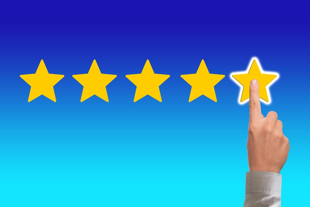 Dedo pulsando la quinta estrella para dejar una reseña de 5 estrellas en Google Business Profile desde el móvil